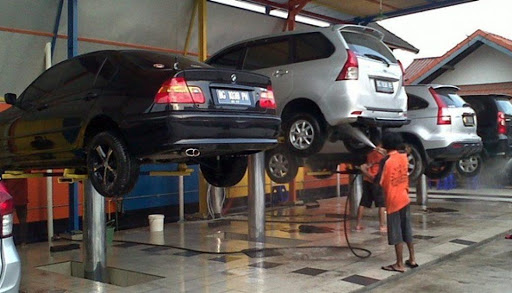 Dùng cầu nâng thực hiện phun rửa gầm ô tô